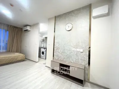 Modern studio apartment with open layout, featuring a washing machine and stylish decor.