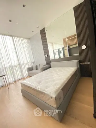 Modern bedroom with floor-to-ceiling windows and stylish decor in a luxury apartment.