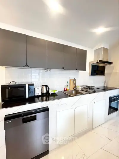 Modern kitchen with sleek appliances and marble countertops in a stylish apartment.