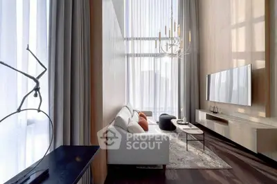 Luxurious modern living room with high ceilings, elegant chandelier, and large windows.