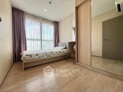 Bright and cozy bedroom with large window and mirrored wardrobe in modern apartment.