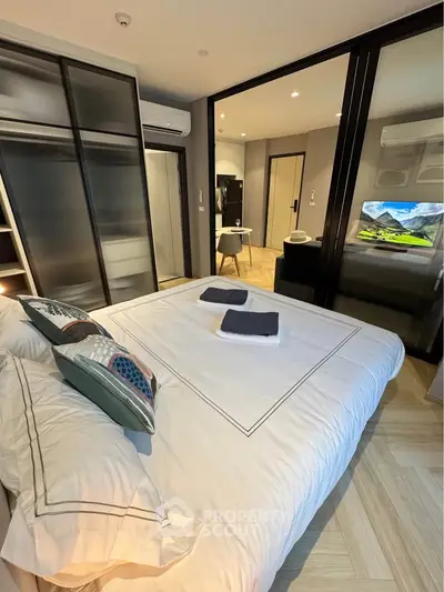 Modern bedroom with stylish decor and sliding glass doors leading to a cozy living area.