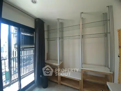 Spacious room with large windows and built-in shelving, perfect for storage or display.