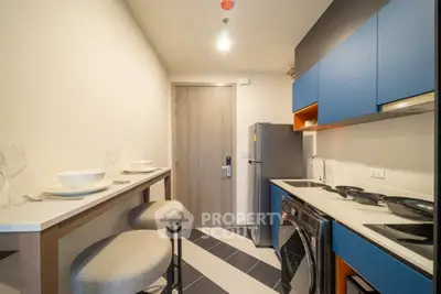 Modern compact kitchen with sleek appliances and stylish bar seating