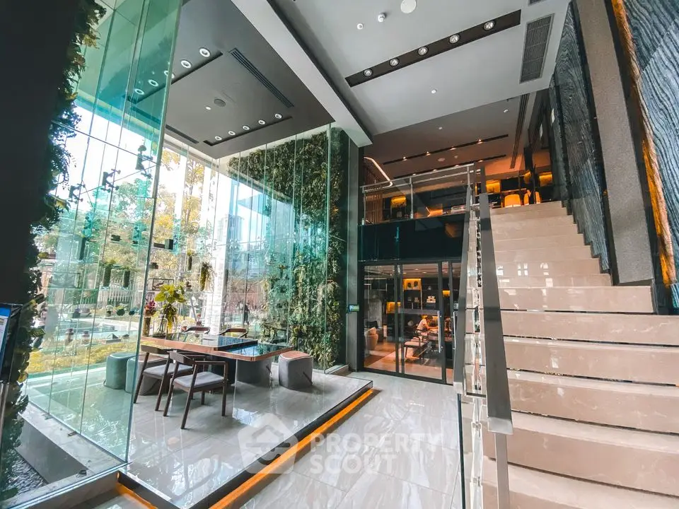 Luxurious modern building entrance with glass walls and elegant staircase