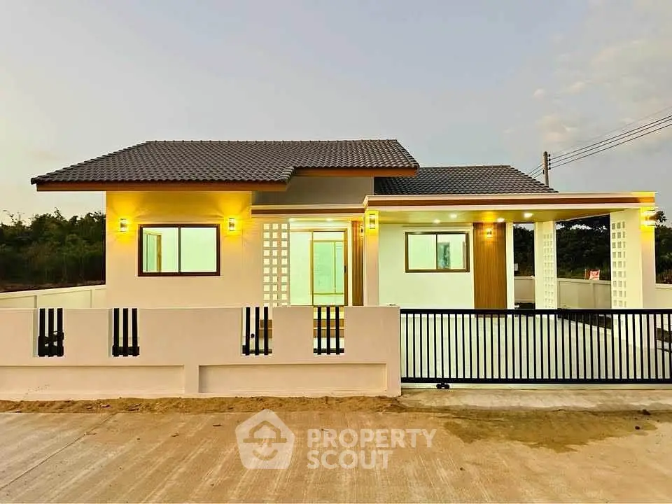 Charming modern single-story home with stylish exterior lighting and gated entrance.