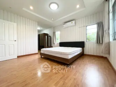 Spacious bedroom with wooden flooring and modern decor