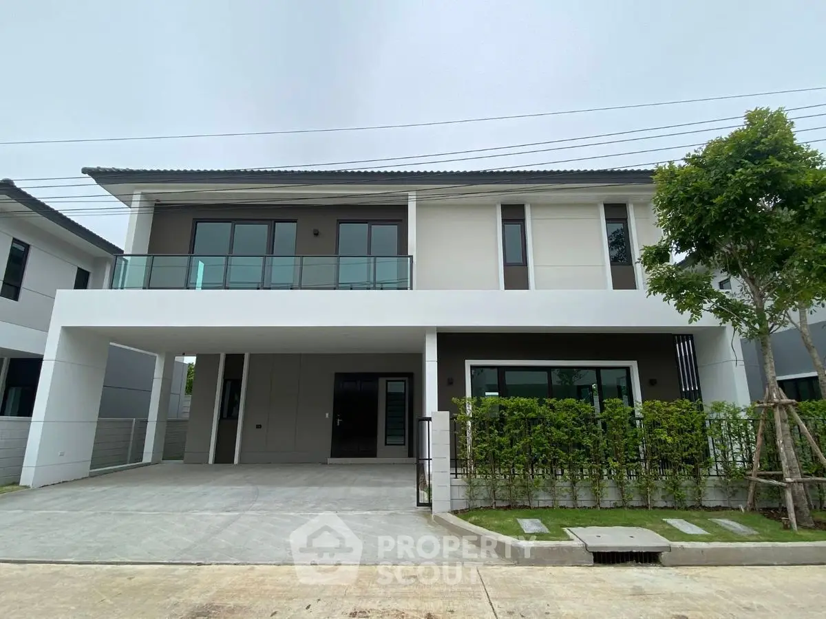 Modern two-story house with spacious driveway and lush greenery