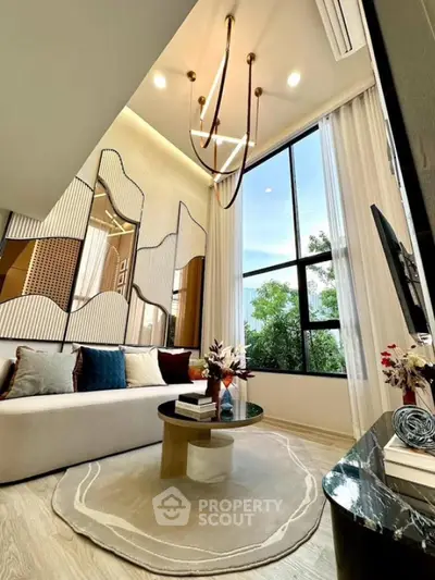 Luxurious modern living room with high ceilings and elegant chandelier