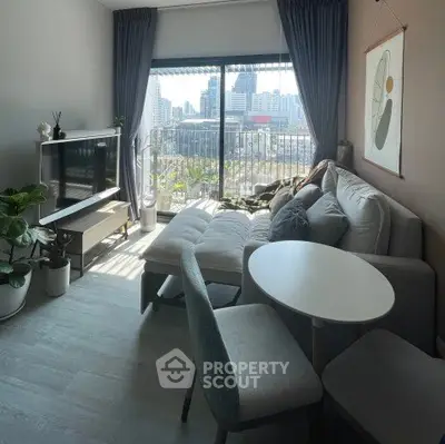 Modern living room with city view, stylish furniture, and natural light.