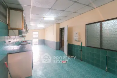 Spacious kitchen with tiled floor and ample natural light, perfect for culinary enthusiasts.