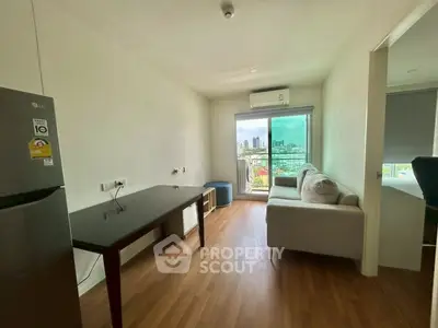 Modern living room with city view, featuring sleek furniture and natural light.