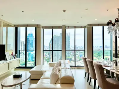 Luxurious living room with panoramic city views and elegant furnishings in a high-rise apartment.
