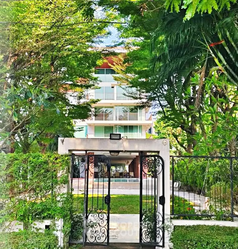 Luxurious modern building surrounded by lush greenery and elegant entrance gate