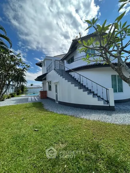 Stunning two-story house with lush garden and ocean view, perfect for serene living.