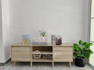 Modern minimalist living room with stylish wooden console and decorative accents.