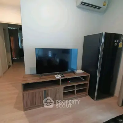 Modern living room with sleek TV stand and large refrigerator