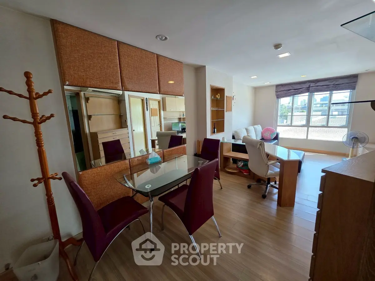 Spacious study room with modern furniture and large windows offering natural light.