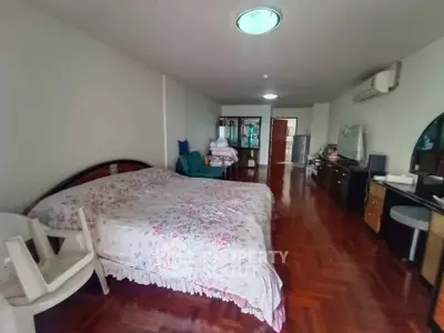 Spacious bedroom with elegant wooden flooring and cozy furnishings