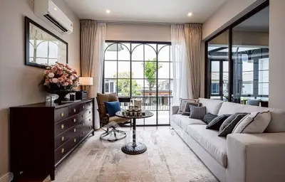 Elegant living room with large windows and stylish decor, featuring a cozy sofa and chic furniture.