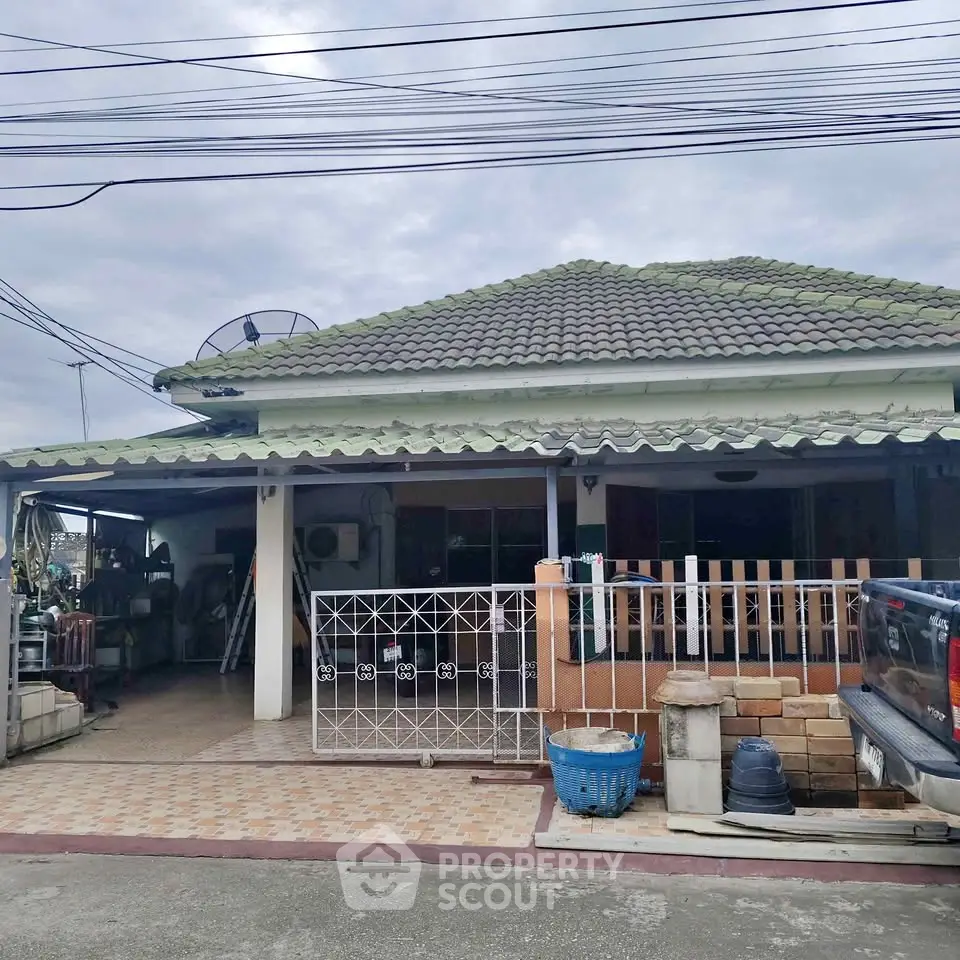 Charming single-story home with tiled roof and gated entrance, perfect for family living.