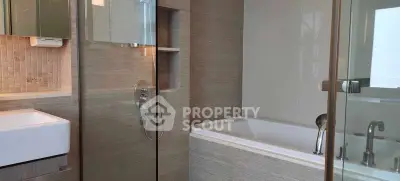 Modern bathroom with sleek design featuring bathtub and glass shower enclosure.