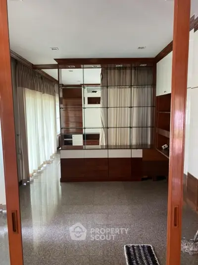Spacious room with large windows and elegant wooden cabinetry