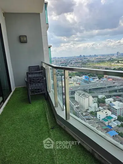 Spacious balcony with stunning city view and artificial grass flooring.