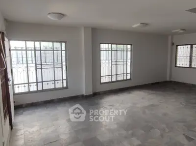 Spacious empty room with large windows and tiled floor, perfect for customization.