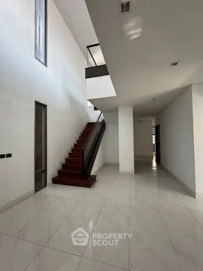Spacious modern interior with elegant staircase and sleek design, perfect for contemporary living.
