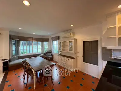 Spacious living room with large windows and elegant dining area, perfect for family gatherings.