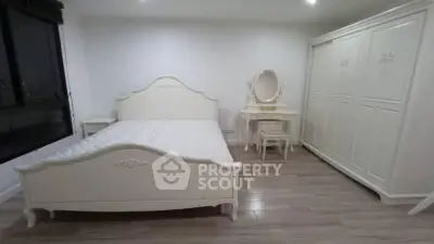 Elegant white bedroom with classic furniture and wooden flooring