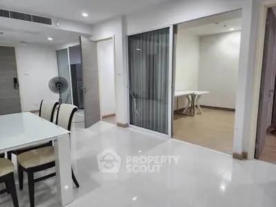 Spacious modern apartment interior with dining area and sliding glass doors.