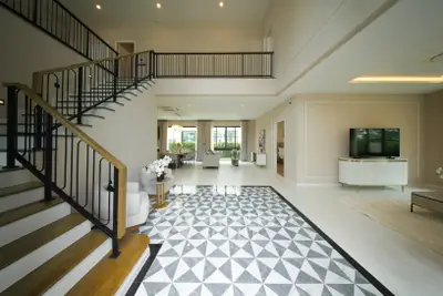 Luxurious open-plan living room with elegant staircase and modern decor