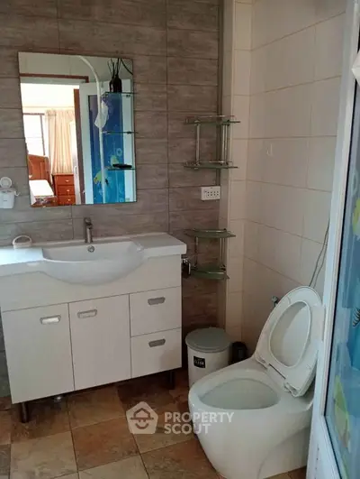 Modern bathroom with stylish sink and mirror, featuring tiled walls and floor.