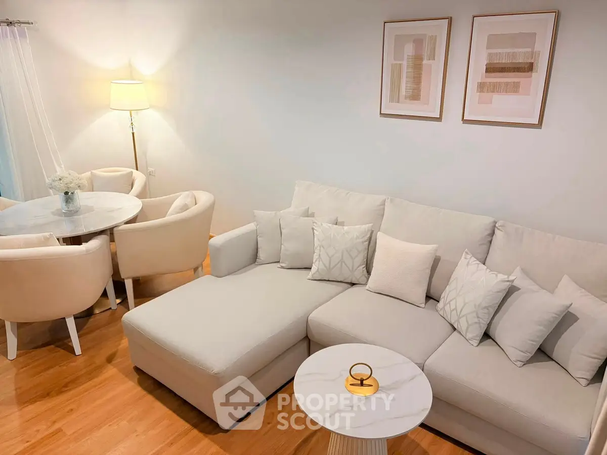 Elegant living room with modern decor, featuring a cozy sectional sofa and stylish dining area.