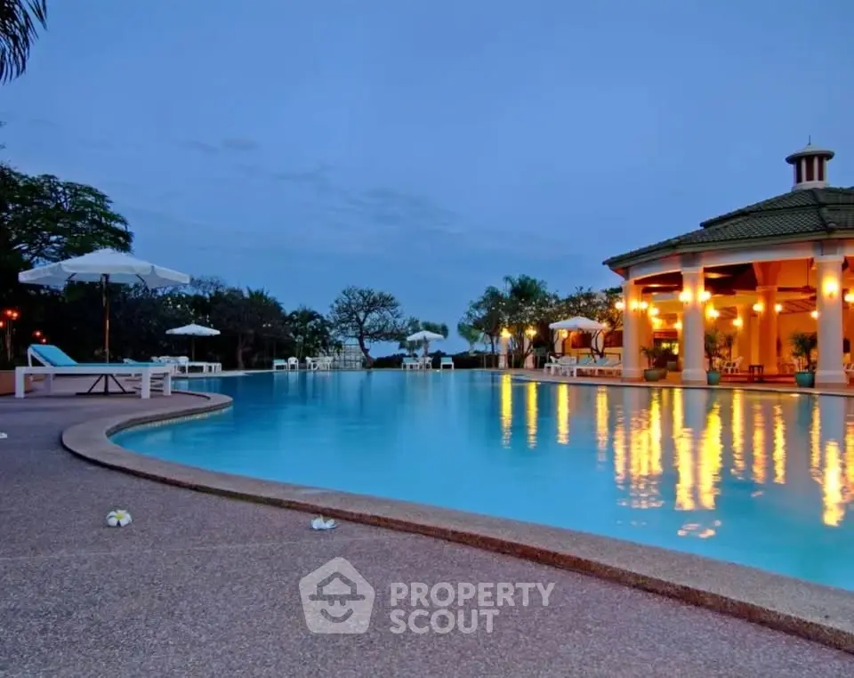 Luxurious resort-style pool with ambient evening lighting and elegant architecture.