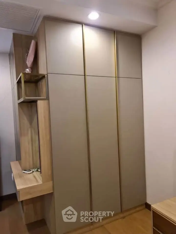 Modern built-in wardrobe with sleek design and wooden accents in a stylish interior space.