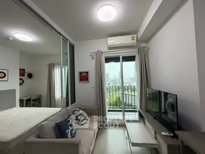 Modern studio apartment with balcony and city view, featuring cozy living area and stylish decor.