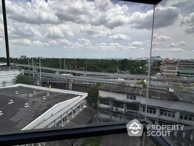 Stunning cityscape view from high-rise building window showcasing urban skyline and lush greenery.