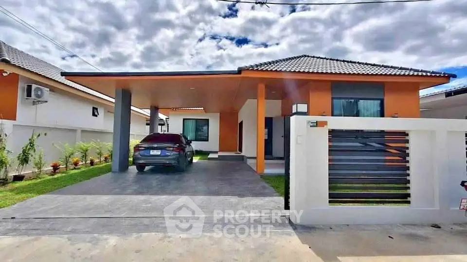 Modern single-story house with carport and landscaped front yard under a cloudy sky.