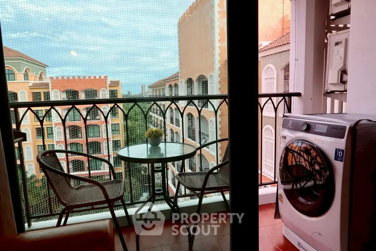 Charming balcony with washing machine and scenic view of Mediterranean-style buildings.