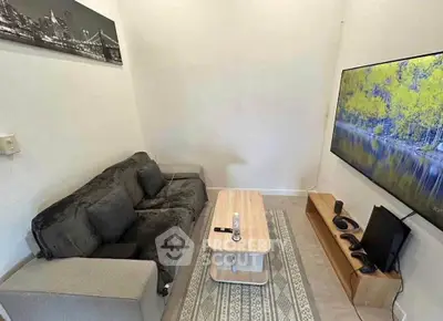 Cozy living room with modern decor, featuring a plush sofa, sleek TV setup, and stylish coffee table.