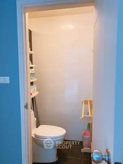 Compact bathroom with modern fixtures and white tiled walls, perfect for efficient space utilization.