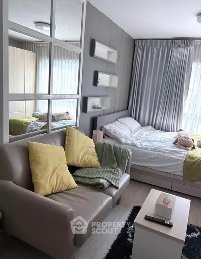 Cozy bedroom with modern decor, featuring a comfortable bed, stylish sofa, and ample natural light.