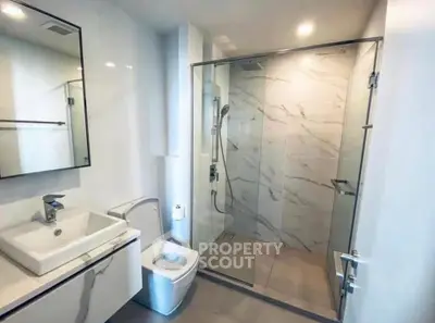 Modern bathroom with glass shower and sleek fixtures in a contemporary home.