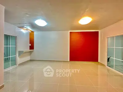 Spacious modern living room with glossy tiled floors and vibrant accent wall.