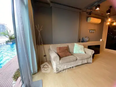 Stylish living room with pool view, cozy sofa, and modern decor in a luxury apartment.