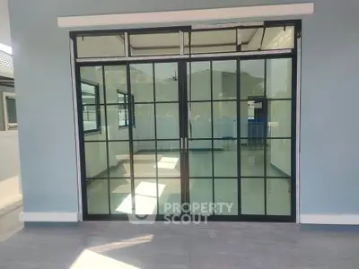 Modern glass sliding doors leading to a spacious interior with sleek design.