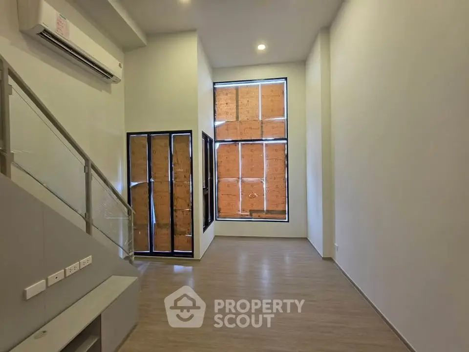 Modern loft-style living room with high ceilings and large windows